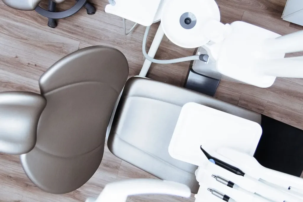 Top down view of a dentist chair and dentist's tools.
