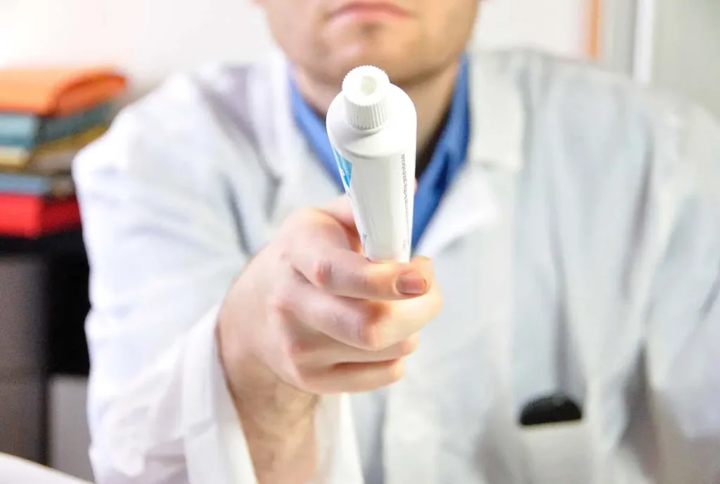 Dentist holding a tube of prescription toothpaste.